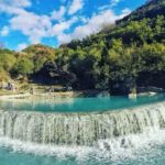 Thermal bath in benja filled with blue water and surrounded by green trees
