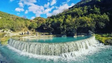 Thermal bath in benja filled with blue water and surrounded by green trees