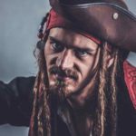 Pirate man with long hair holding a knife