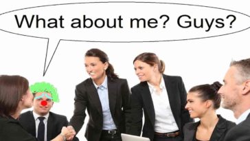 Office meeting men and women in suit a guy looks like clown with red nose and green hair