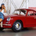 Classic red porsche 911 toy with a toy doll standing in front
