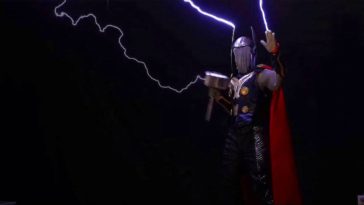 Thor cosplay guy holding electrified hammer and wearing red cape