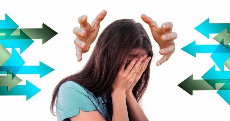 Brunette woman in a teal T-shirt covering her face anxiously