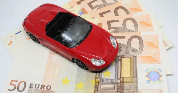 Red Convertible Porsche Toy standing on 50 Euro bills